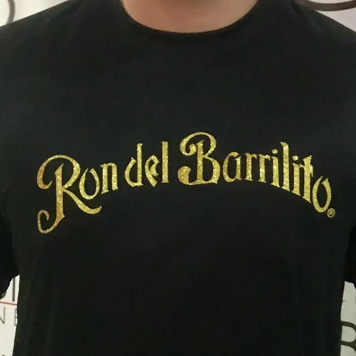 Camiseta negra con el logotipo de una marca puertorriqueña impreso en dorado