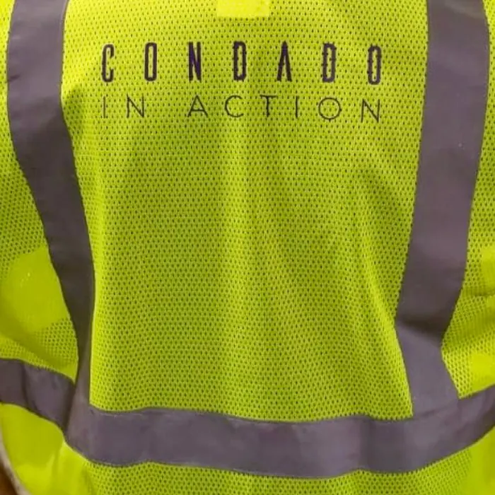 Chaleco de malla de alta visibilidad visto por la espalda, con el nombre de un programa impreso