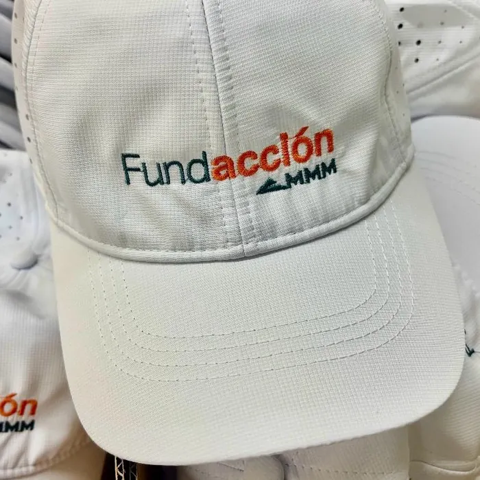 Gorra blanca con el logo de una fundación bordado al frente y en el lateral