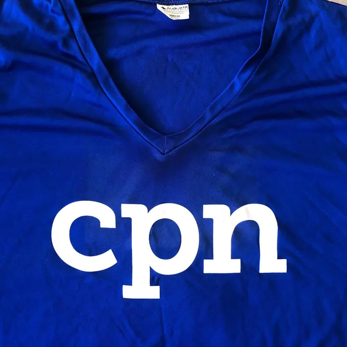 Camiseta deportiva azul de cuello en V con el logo del equipo impreso en blanco al frente