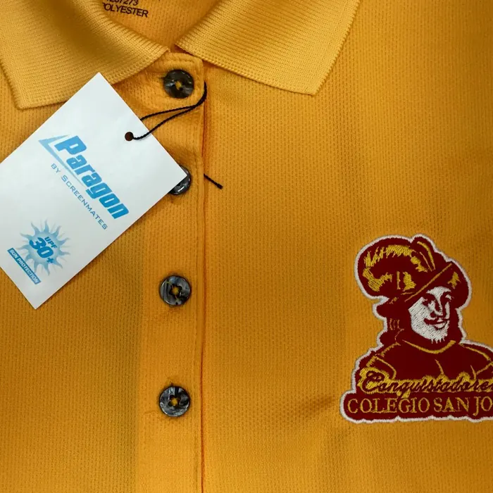 Polo escolar dorado con el escudo del colegio bordado a color en el pecho