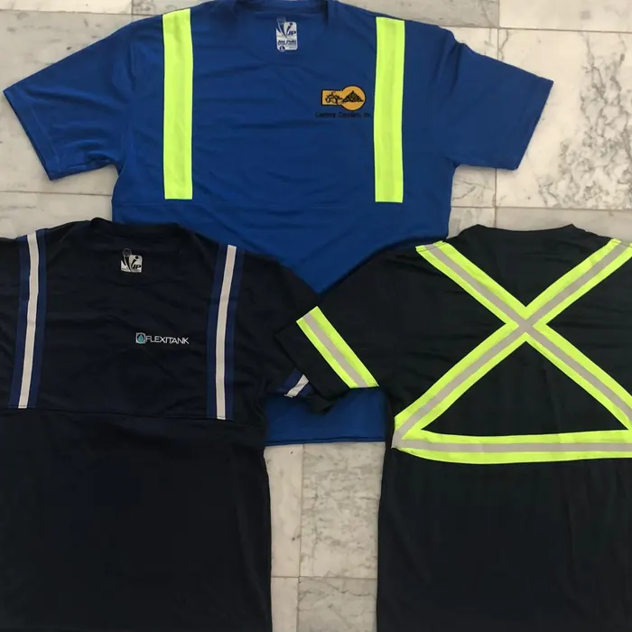 Cuatro camisas de trabajo negras y azules con cintas de alta visibilidad al frente y en la espalda